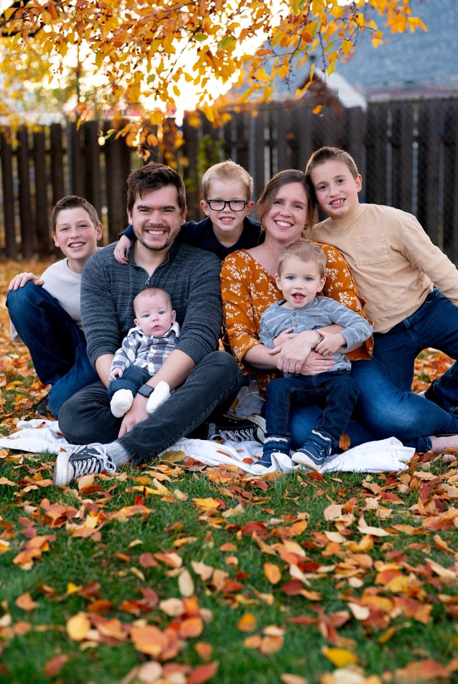 The Walker family — Kevin, his wife, and their five boys — sitting together in fall leaves